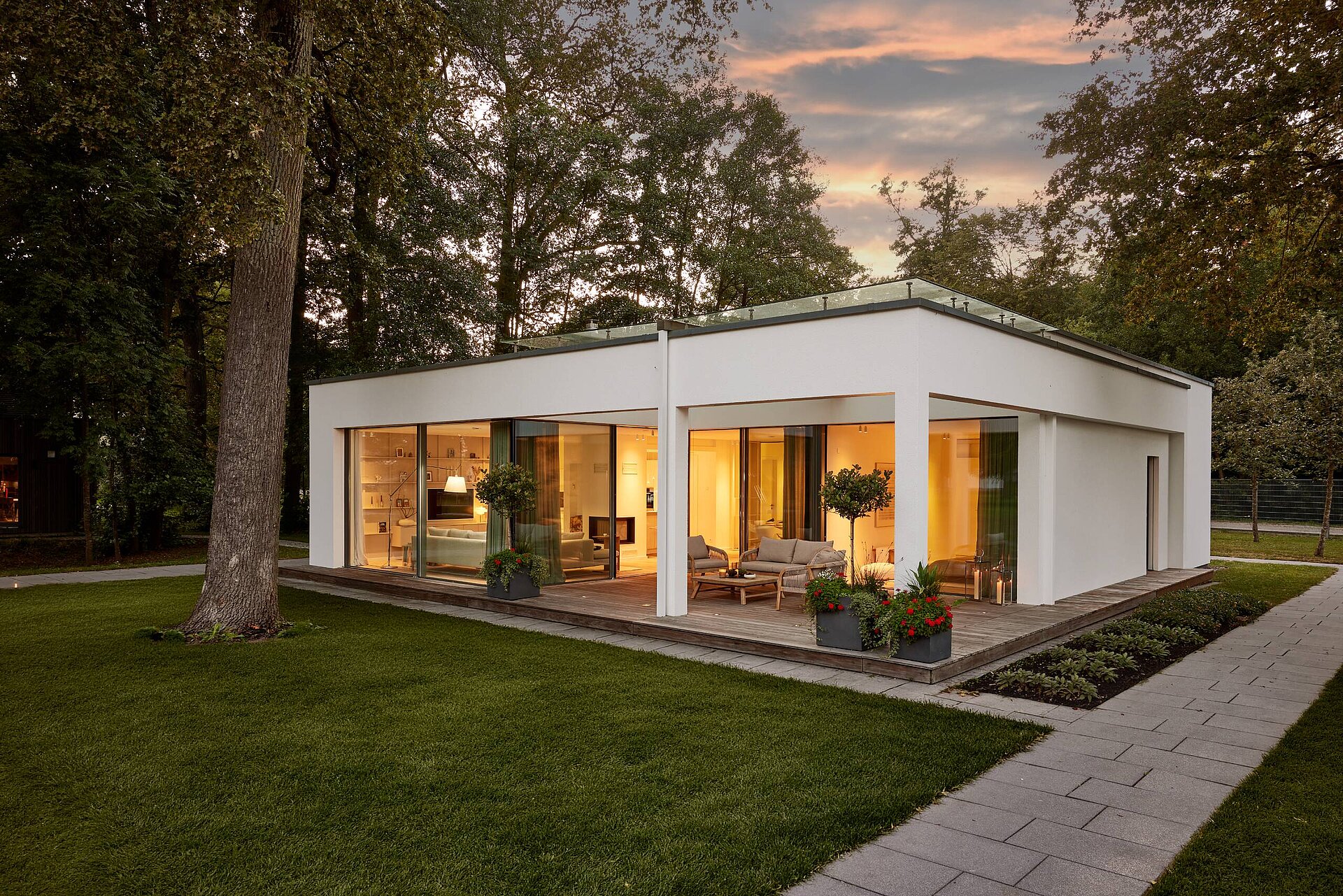 Moderner Bungalow mit Flachdach und Terrasse Moderner weißer Bungalow mit Flachdach, großen Fensterflächen und überdachter Terrasse